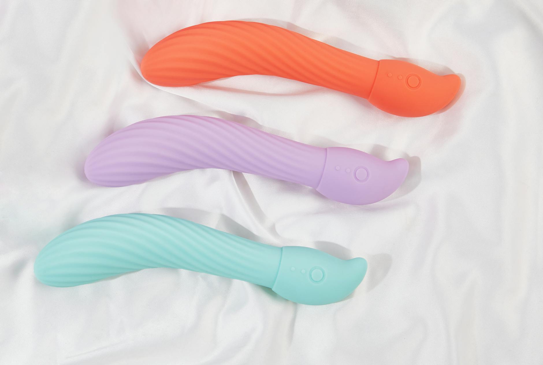 Colorful vibrators with flowers in a holographic gift bag on a bold yellow background