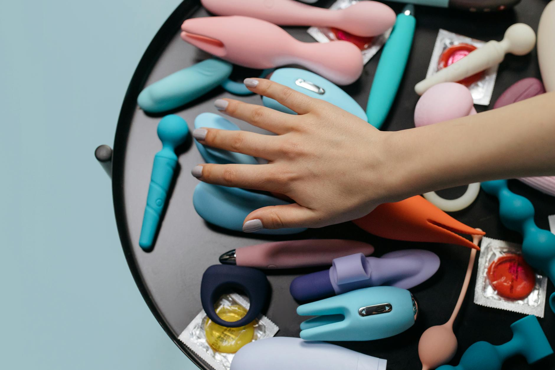 Person holding two colorful vibrators, representing modern intimate wellness tools for different needs