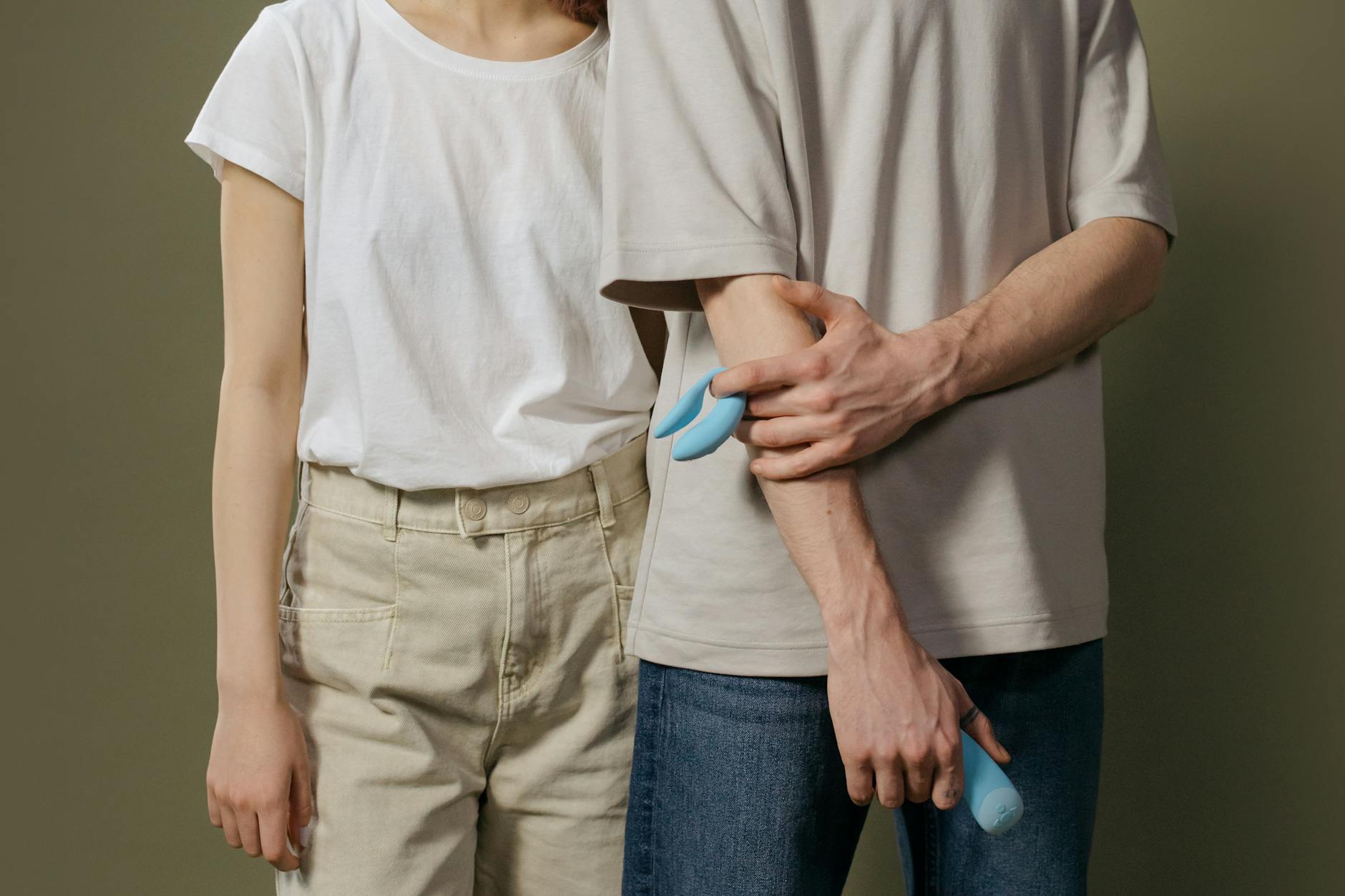 Woman holding a blue clitoral vibrator, demonstrating awareness of vibrator sensitivity management.